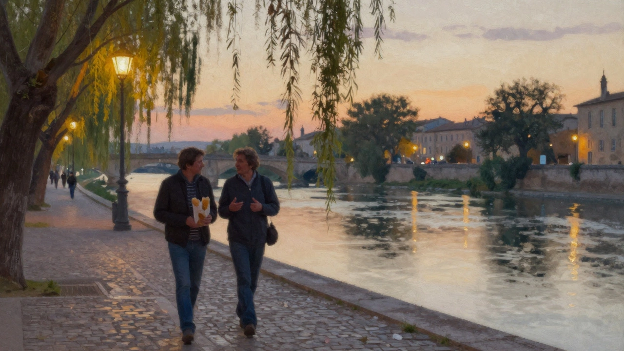 A couple walking peacefully along the River Lez at dusk, city lights reflecting on water under willow trees.